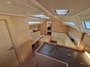 A compact interior with a kitchenette, seating area, and skylights. - Sibenik Sun-Kissed Sailing: A Luxurious Beach Experience in Croatia (Murter)
