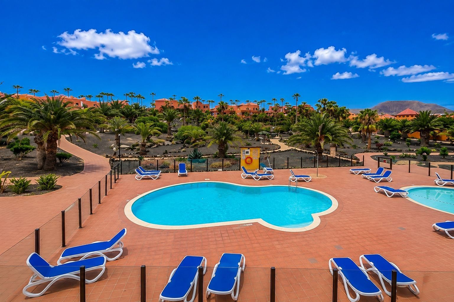 A pool area with multiple sun loungers and a lifeguard stand.
