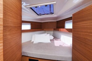 A compact, well-lit interior with a skylight, a bed with pillows, and wooden paneling. - Sun-Kissed Sailing Adventure in Zadar, Croatia (Zadar)