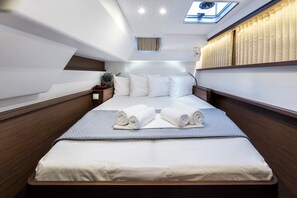A modern hotel room with a large bed, a skylight, and a view of the sea. - Sun-Kissed Sailing Adventure in Islas Sarónicas (Alimos)