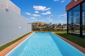 A swimming pool with a view of a residential area and a hill in the background. - GuestReady - Villa Datana with Pool (Mogán)