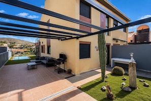 Eine moderne Außenpatio mit Pool, Sitzbereich und Grill.