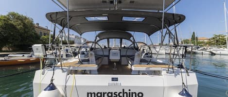 Un barco llamado 'maraschino' con cubierta cerrada, zona de estar y timón.