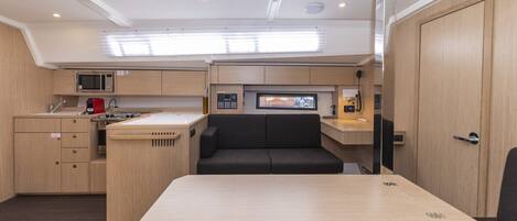 A compact kitchen with a microwave, stove, and seating area.