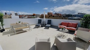 A rooftop terrace with a table, chairs, and a sofa. - GuestReady - 01D Livian Suites Ext 2pax (Las Palmas de Gran Canaria)
