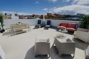 Eine Dachterrasse mit Tisch, Stühlen und einer Sitzecke.