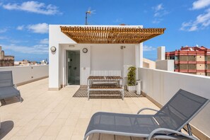 Terraço no terraço com pérgola, área de estar e vista para a paisagem urbana.
