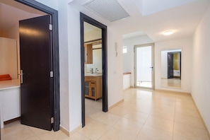 A modern interior with a hallway leading to a bathroom and a kitchen area. - GuestReady - Tarantos Sea View and Pool (Playa del Ingles)