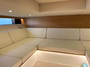 A modern interior with a sectional sofa, recessed ceiling lighting, and a wooden panel wall. - Sun-kissed Sailing Adventure in Split-Dalmatia, Croatia (Seget Donji)