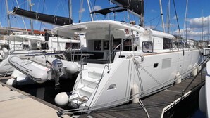 A marina with a white yacht docked, featuring a covered deck, a cabin, and a helipad.