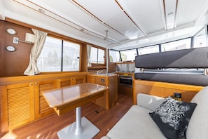 A compact galley with wooden cabinetry, a dining table, and a bench. - Sun-Kissed Sailing Adventure in Zadar, Croatia (Zadar)