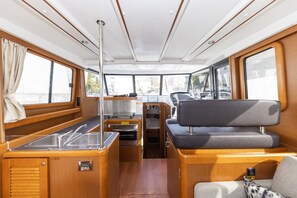 A boat interior with a dining area, seating, and a control panel. - Sun-Kissed Sailing Adventure in Zadar, Croatia (Zadar)