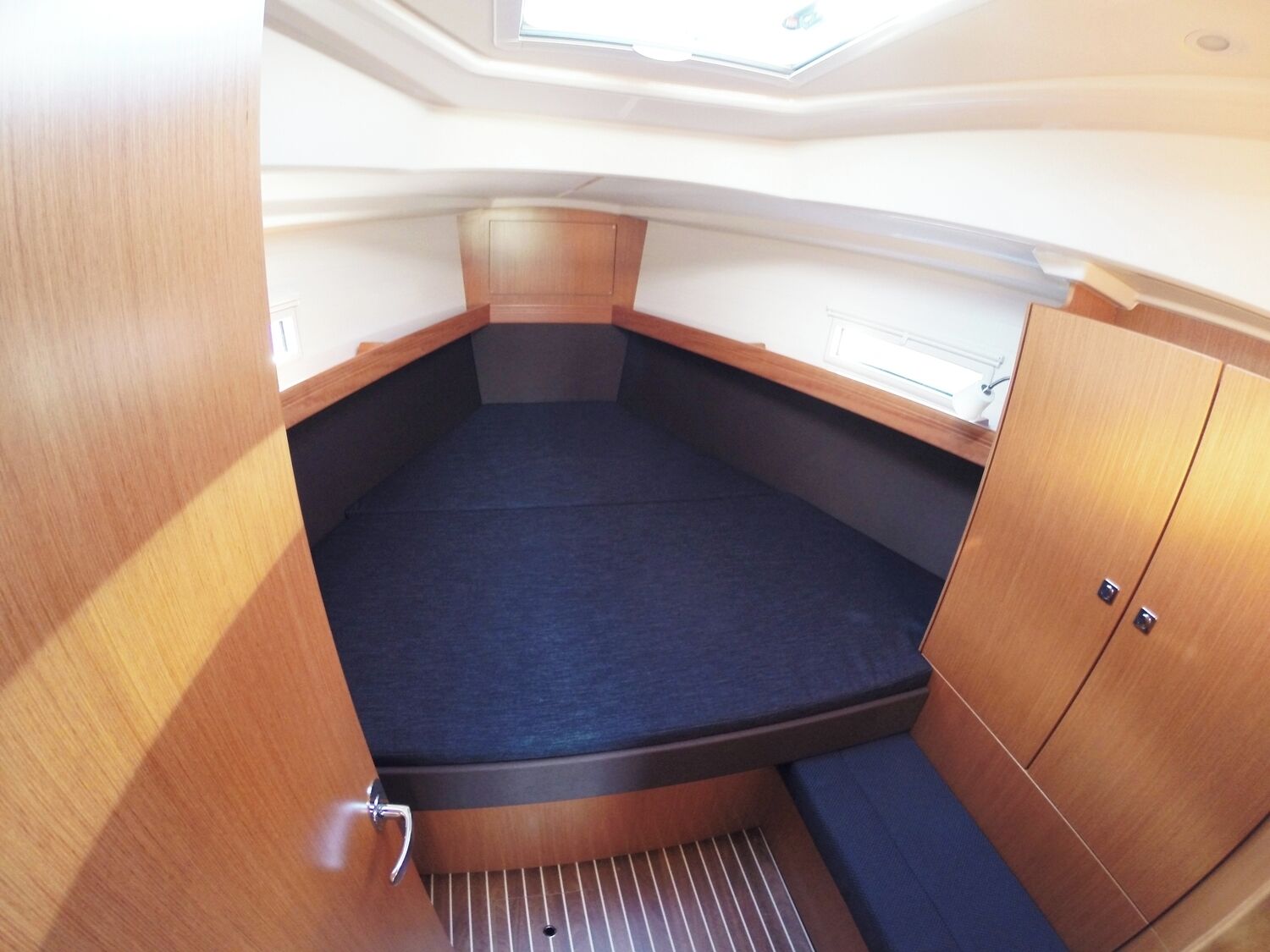 A compact cabin with a bunk bed, a small window, and a door.