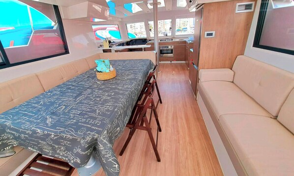 Un intérieur compact comprenant un coin repas, une kitchenette et un espace salon.