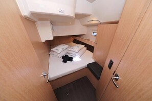 Una cabana senzilla amb un llit superposat, una cuineta petita i un armari.