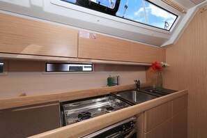 Cuina compacta amb un finestral situat al sostre, electrodomèstics d'acer inoxidable i armaris de fusta.