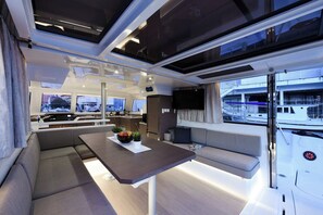 Un intérieur moderne comprenant un coin repas, des sièges et une vue sur le port de plaisance.