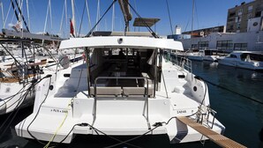 A yacht docked at a marina with multiple boats, a clear sky, and buildings in the background. - Sun-Kissed Sailing Adventure in Zadar, Croatia (Zadar)