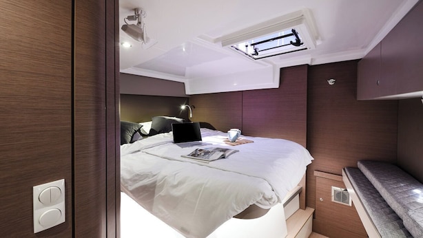 A compact bedroom with a bed, a laptop, a cup, and a magazine on the bed. - Sun-Kissed Sailing Adventure in Zadar, Croatia (Zadar)