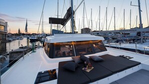 A yacht with a covered deck area, seating, and a view of the marina. - Sun-Kissed Sailing Adventure in Zadar, Croatia (Zadar)