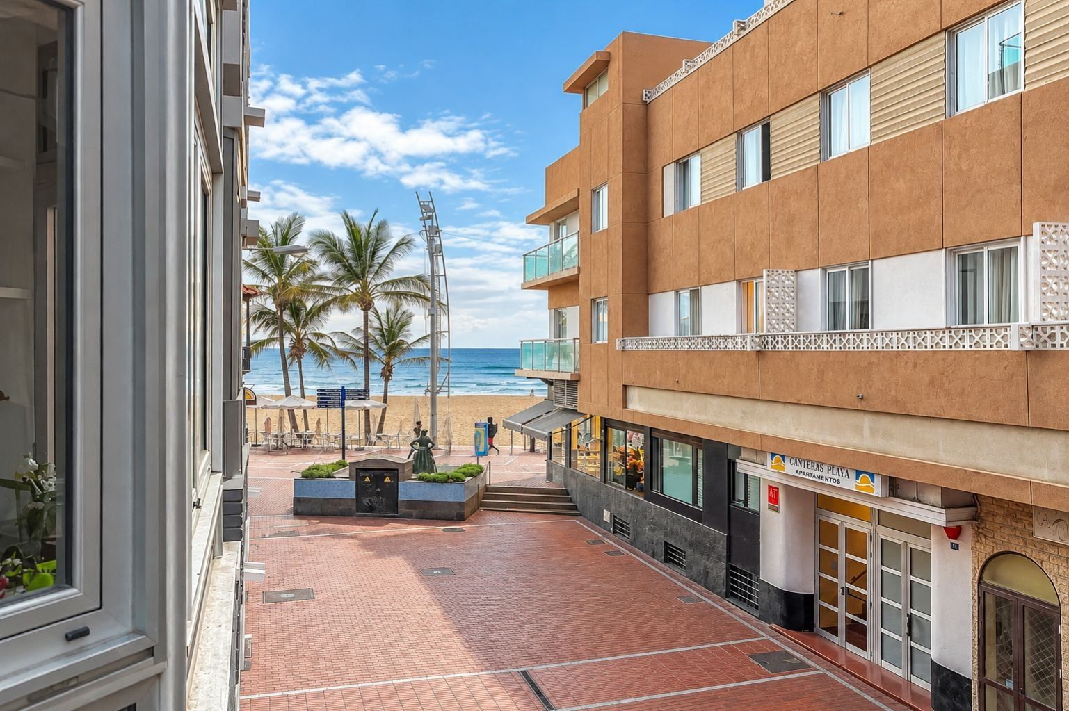 A hotel with a beach view, outdoor seating, and a restaurant.