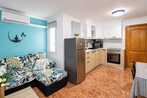 A compact kitchen with a refrigerator, microwave, and oven.