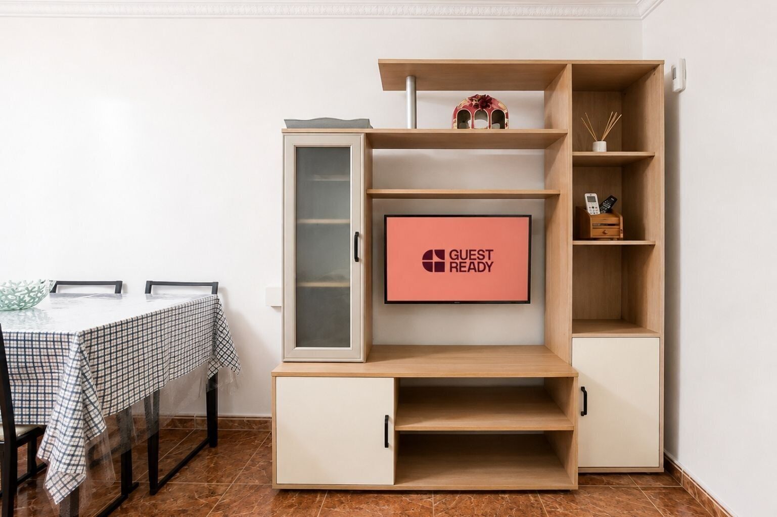 Una sala de estar moderna con un televisor de pantalla plana, una mesa de comedor y un mueble empotrado.
