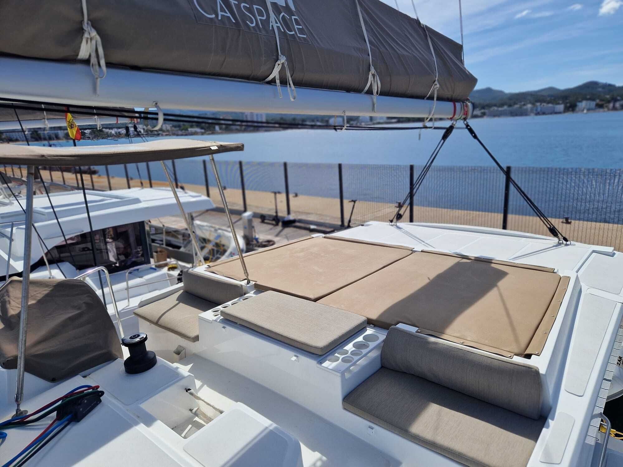 A boat deck with a covered area, seating, and a view of the water.