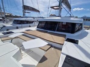 A sailboat with a covered deck area, a window, and a name 'BALI CATSPACE' visible. - Sun-Kissed Sailing Adventure in the Majestic Islas Baleares (Sant Antoni de Portmany)