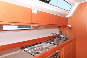 A compact kitchen with a gas stove, stainless steel sink, and a skylight above. - Sun-Kissed Sailing Adventure in Zadar, Croatia (Biograd na moru)