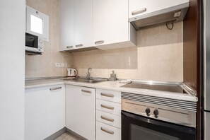 A modern kitchen with white cabinets, a stainless steel oven, and a microwave. - GuestReady - Retreat with Private Pool (Caleta de Fuste)