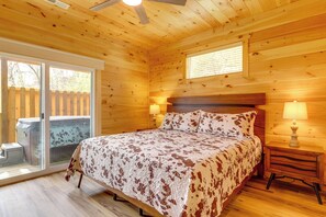 Ein Schlafzimmer einer Holzhütte mit einem Bett, Nachttischen und einem Fenster.