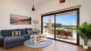 Ein modernes Wohnzimmer mit einer Couch, einem Couchtisch und einem Gemälde an der Wand.