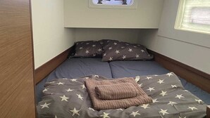 A compact bedroom with a single bed, a window, and a small overhead light. - Sun-kissed Sailing Adventure in Split-Dalmatia, Croatia (Trogir)