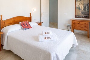 Ein Hotelzimmer mit einem hölzernen Bett, einem Nachttisch, einem kleinen Tisch und einem Bild an der Wand.