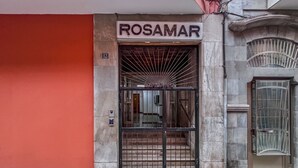 L'ingresso di un edificio con un cartello che riporta 'ROSAMAR' e il numero '12' sopra la porta.
