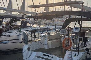 Eine Segelyacht liegt in einer Marina festgemacht, mit sichtbarer Takelage und einer Winde.