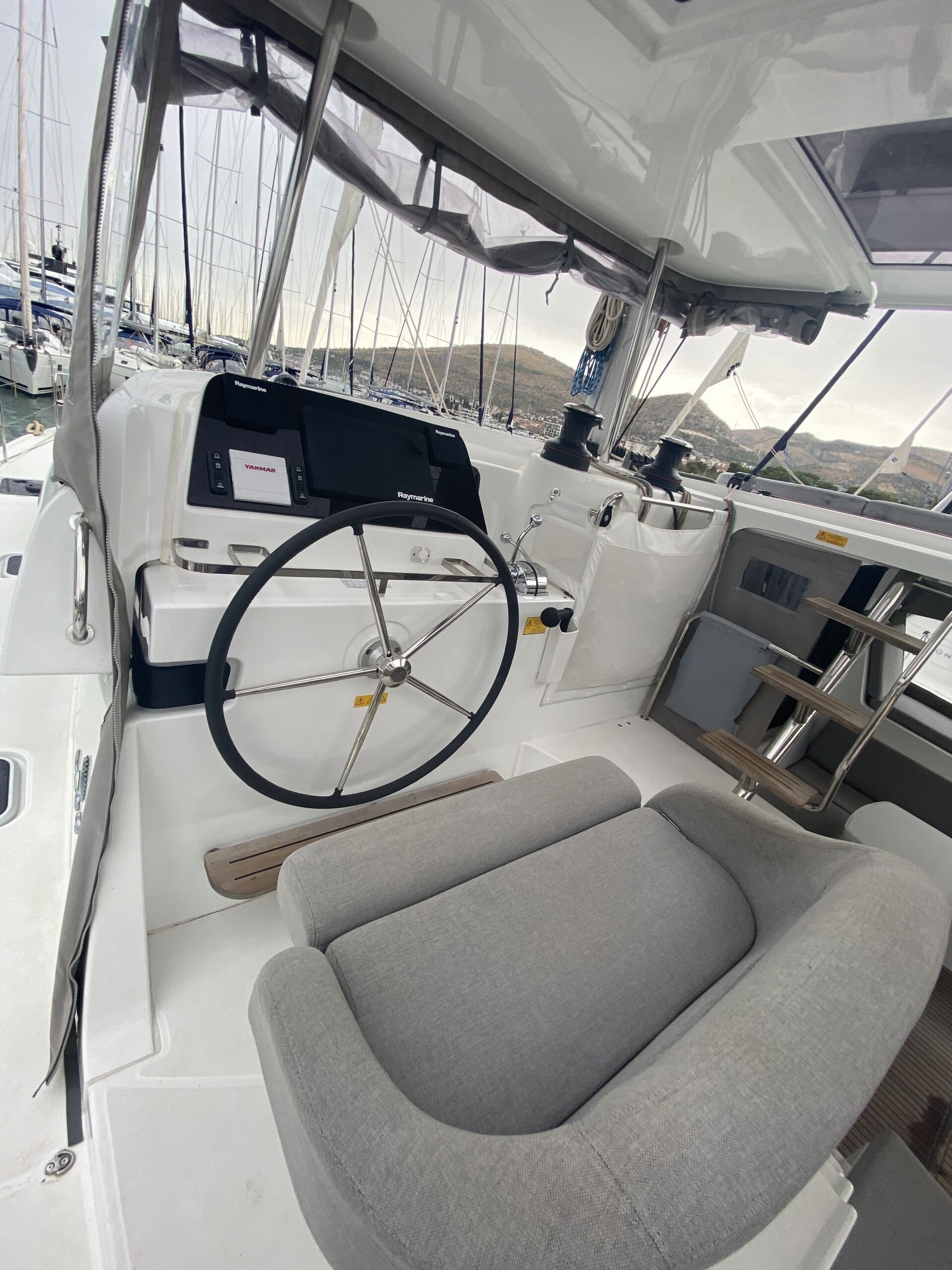 L'intérieur d'un bateau, avec un volant, un panneau de commande et des sièges rembourrés.