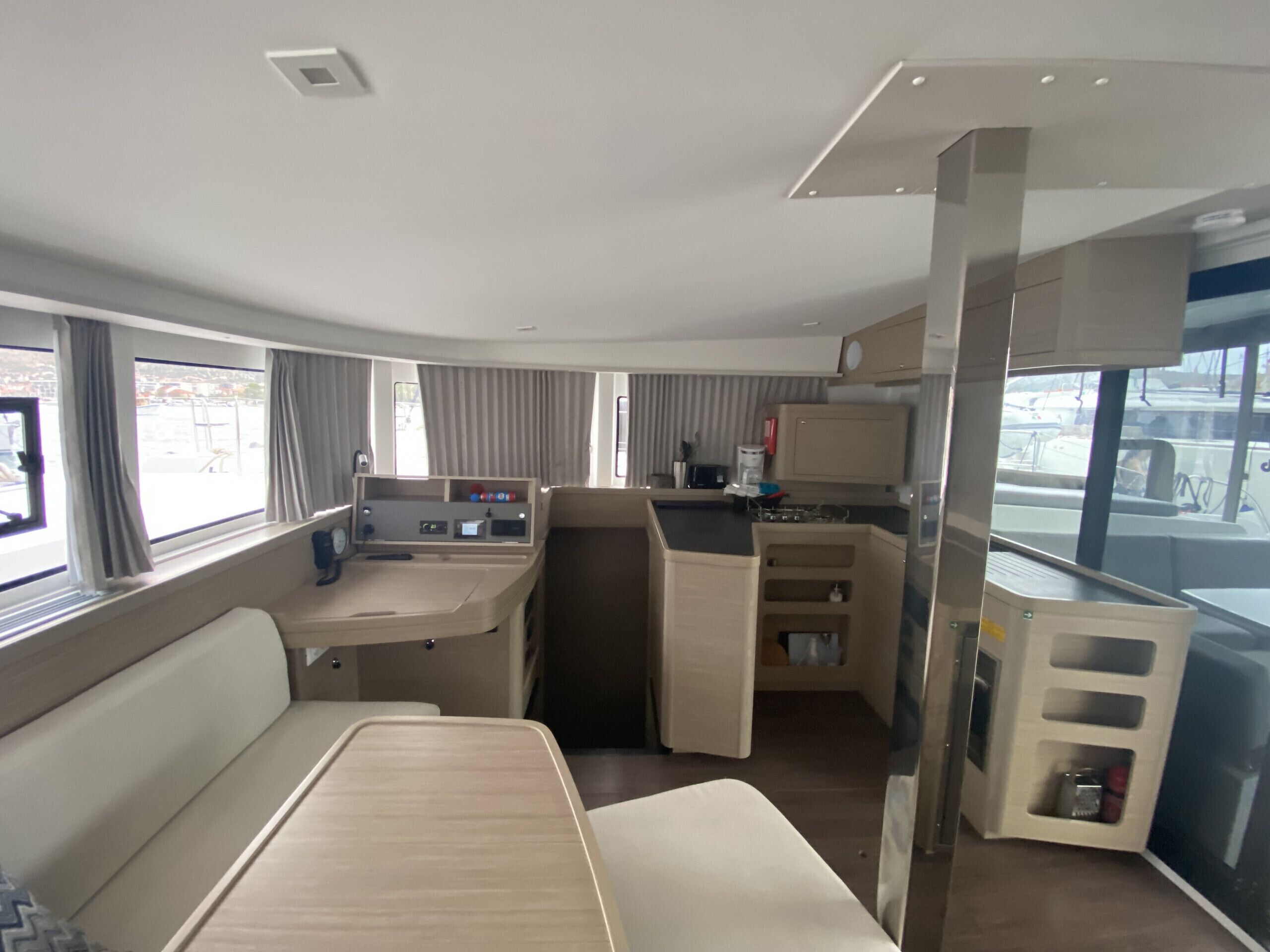 A compact RV interior with a kitchenette, a dining area, and a seating space.