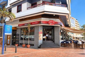 Un restaurante con terraza, un cartel de menú visible y un letrero que indica que es un restaurante.