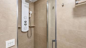 A modern shower with a handheld showerhead and a wall-mounted control panel.