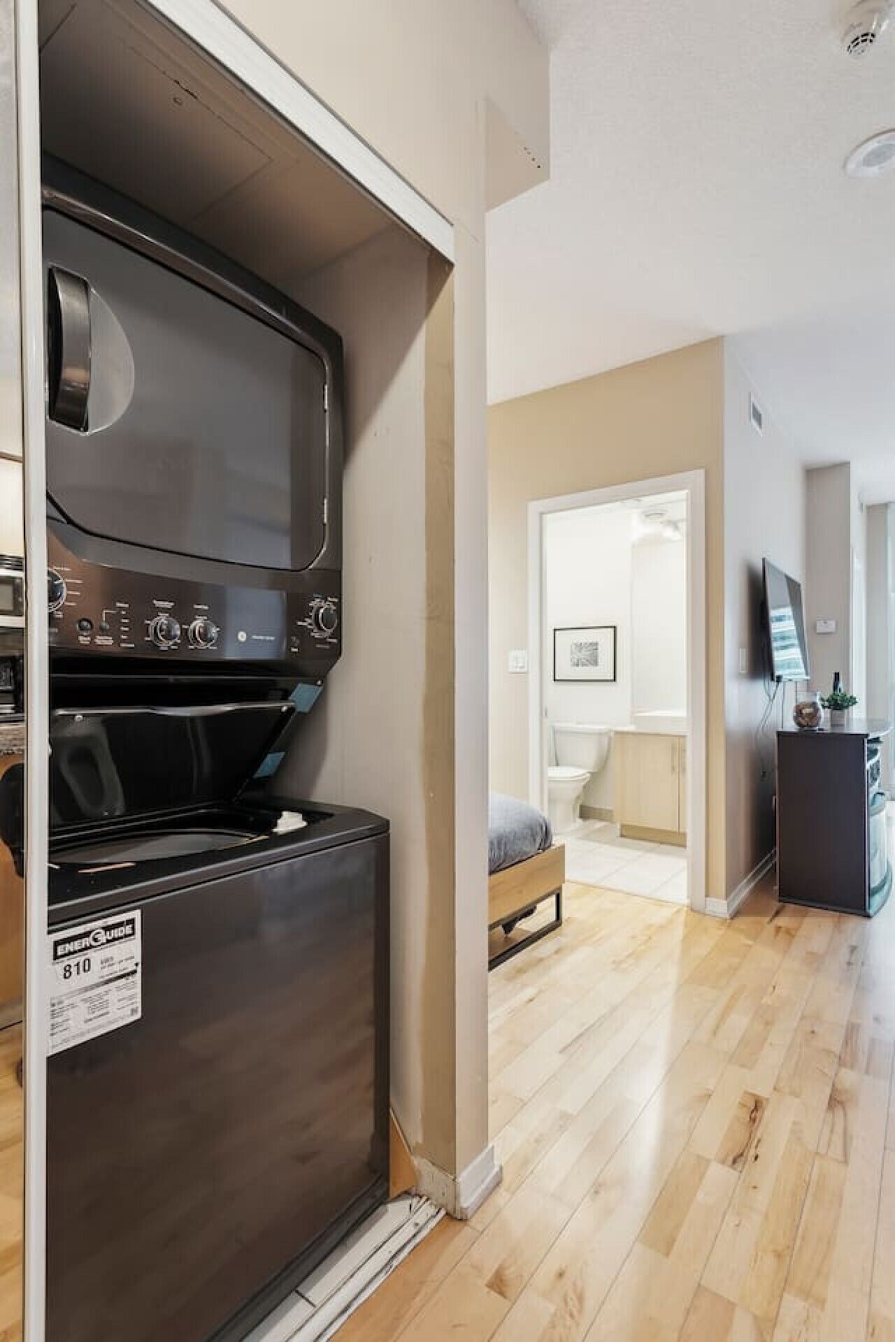Una cucina con frigorifero in acciaio inossidabile, microonde e forno. Nell'ambiente adiacente, una panca in legno.