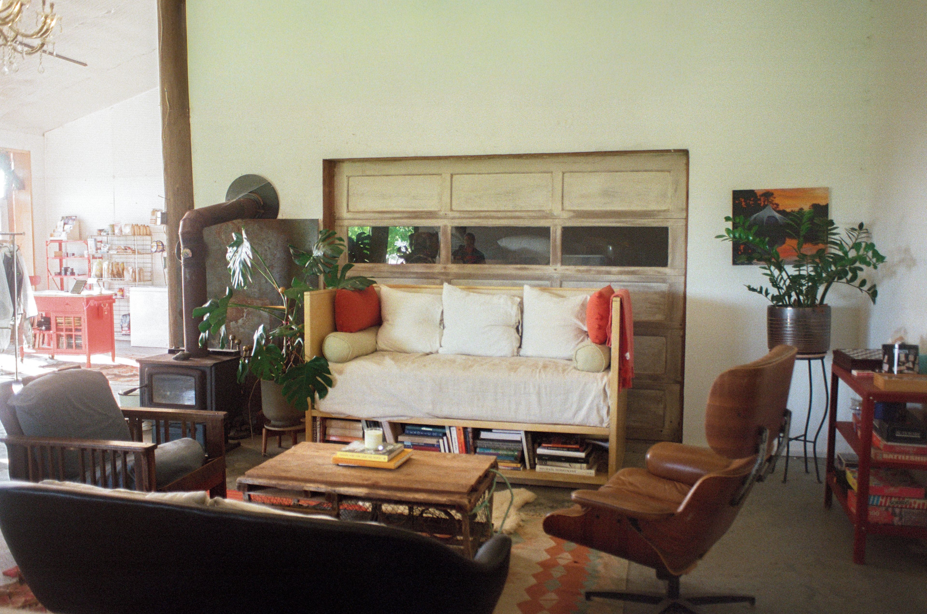 A cozy living room with a sofa, armchairs, a coffee table, and a bookshelf.