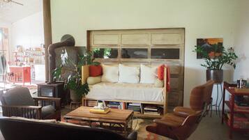 A cozy living room with a sofa, armchairs, a coffee table, and a bookshelf.
