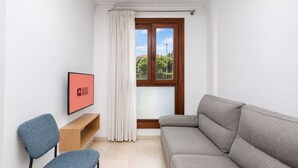 Ein modernes Wohnzimmer mit einem grauen Sofa, einem blauen Sessel, einem Holztisch und einem gerahmten Bild an der Wand.
