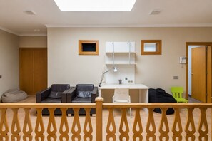 A room with a desk, two chairs, a bed, a small table, and a window. - GuestReady - Naranjo Duplex Central Place (Telde)