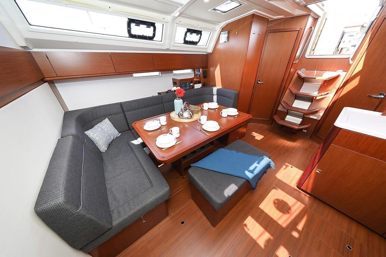 A compact galley with a dining table, a sofa, and a small kitchenette.