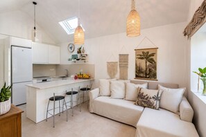 A modern kitchen with white cabinets, a central island with stools, and pendant lighting. - GuestReady - Los Tunos BBQ Garden (San Bartolomé de Tirajana)