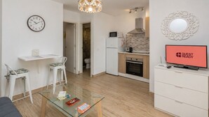 En moderne lejlighed med spiseplads, køkken, opholdsstue og badeværelse.