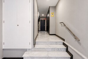 A hallway with marble steps leading to a door at the end. - GuestReady - Artiles Loft Canteras Balcony (Las Palmas de Gran Canaria)